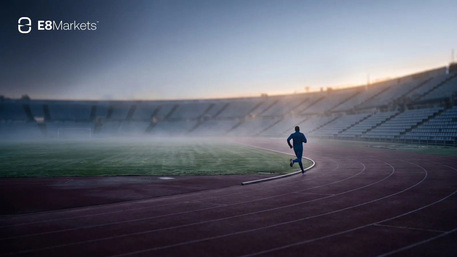 Runner on an empty athletics track at dawn with the E8 Markets logo, cover image for the E8 One rules guide