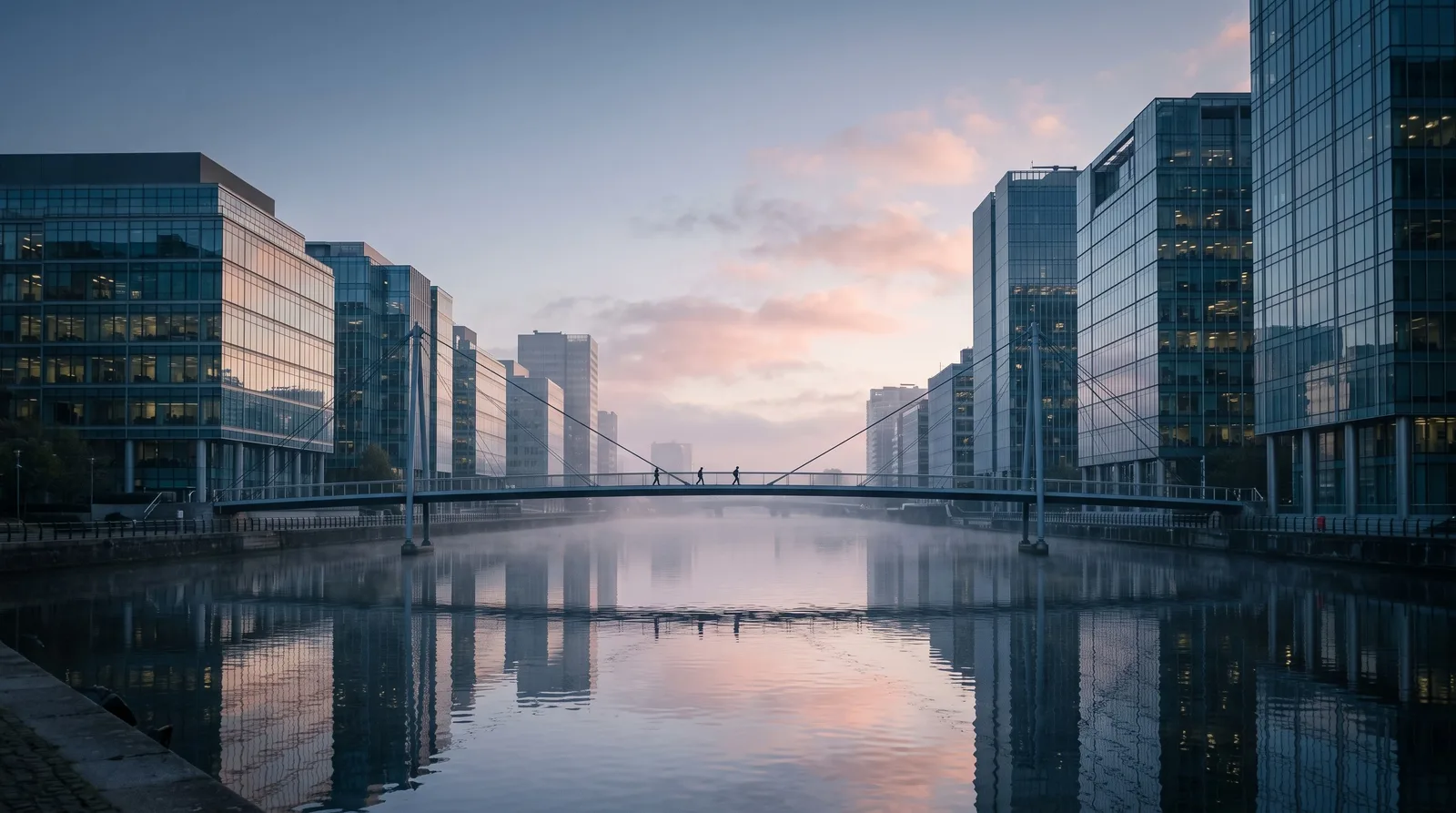 City river at dawn lined with glass office towers and a pedestrian bridge, cover image for the futures prop firms with daily payouts comparison