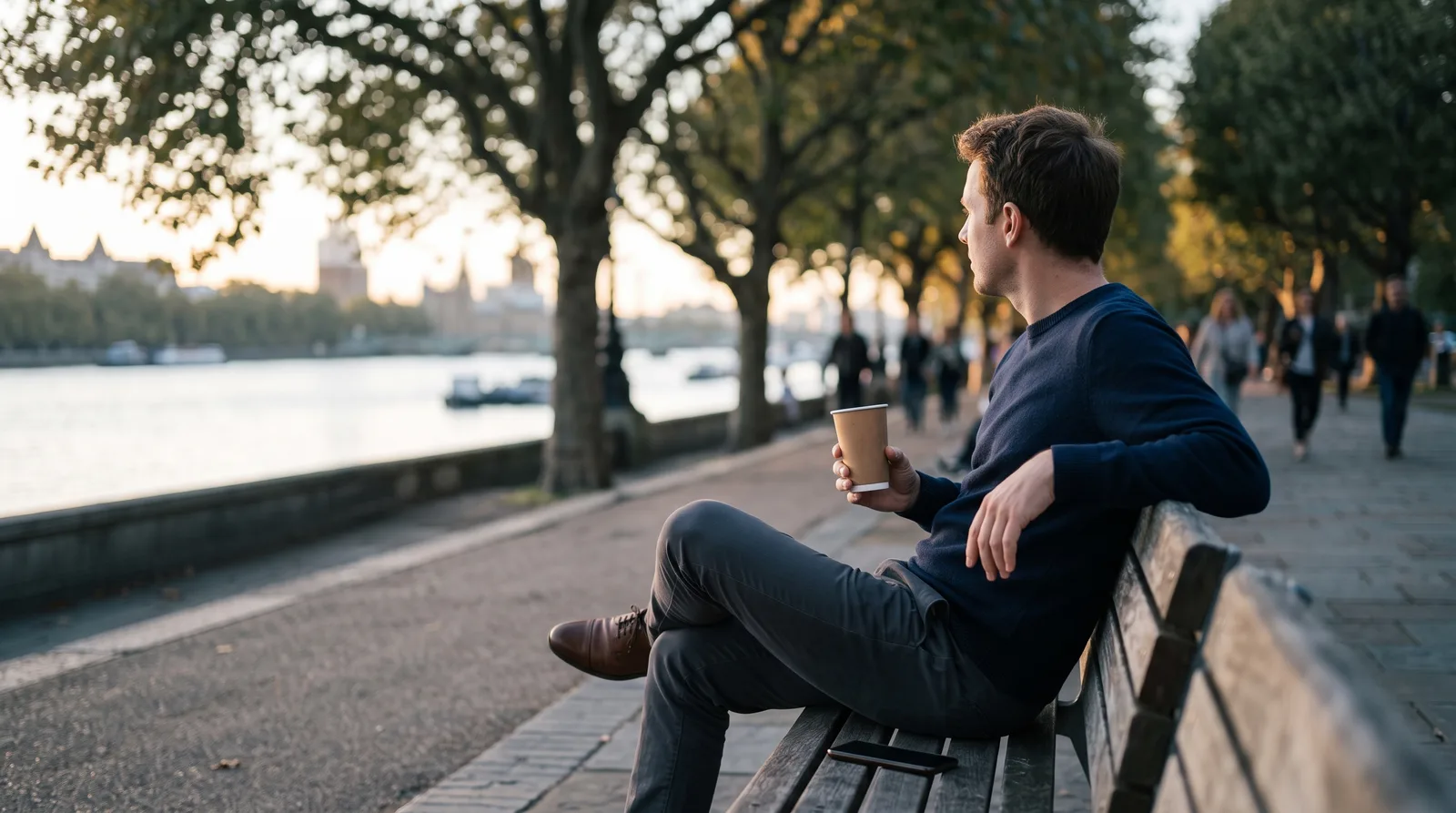 Trader resting on a riverside bench with his phone face down, picturing a Top One Futures account paused after hitting the daily loss limit